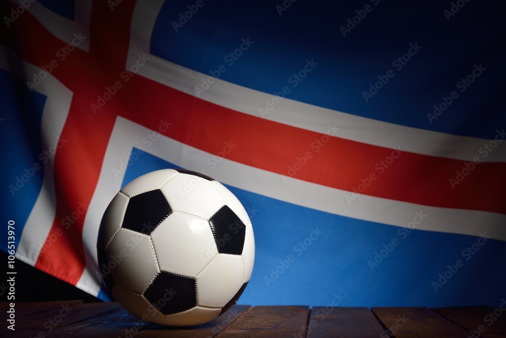 Fototapeta premium Flag of Iceland with football on wooden boards as the background.