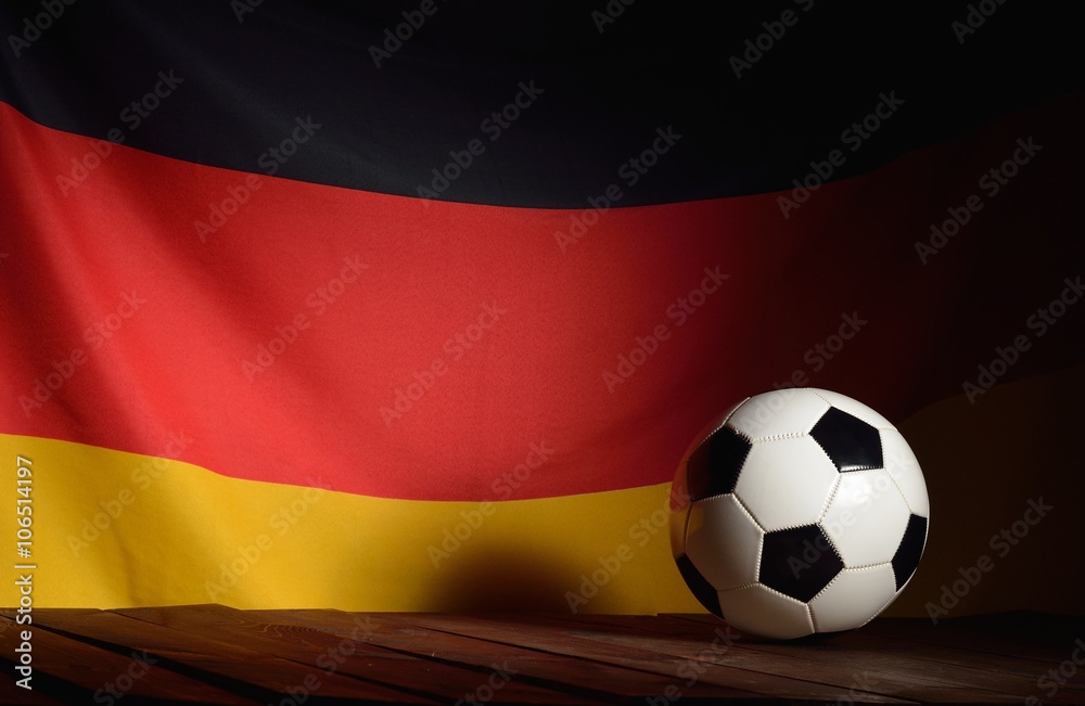Flag of Germany with football on wooden boards as the background. Flag of Germany with football on wooden boards as the background.