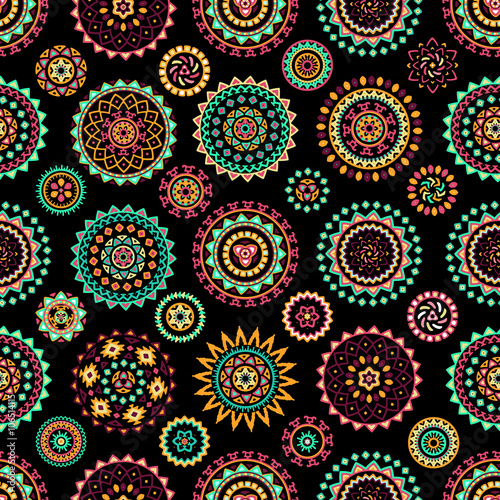 Seamless pattern of bright colorful geometric round ethnic decorative elements. Vector mandala background with bohemian  Oriental  Indian  Arabic  Aztec motifs.