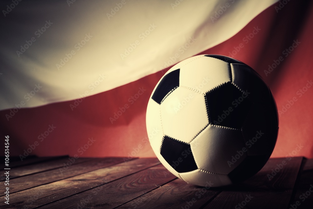 Fototapeta premium Flag of Poland with football on wooden boards as the background. Vintage Style.