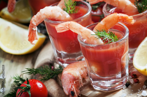 Seafood appetizer: shrimp with tomato sauce, herbs and spices, s photo