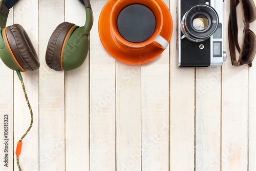 Foto Top view of a analog camera, headphones, sunglasses, coffee cup with negative sp