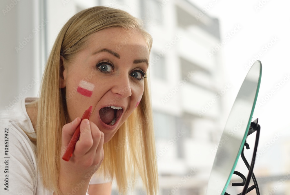 Polish fan cheers football team in the national colors.