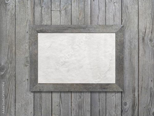 Old gray wooden frame with aged paper hanging on gray wooden boards background. 3d rendering.