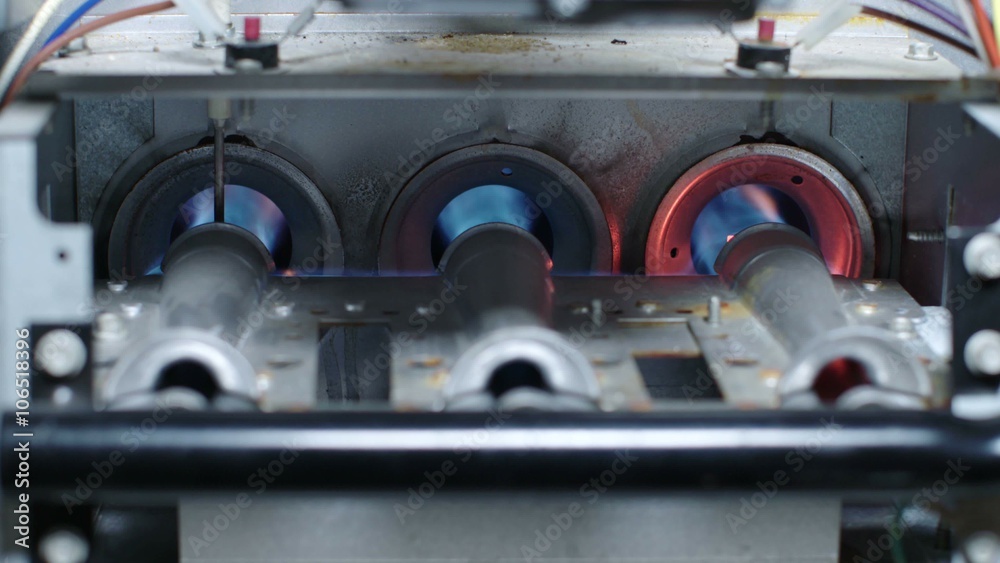A gas furnace heater ignites in blue flame in 4K slow motion 60 fps.