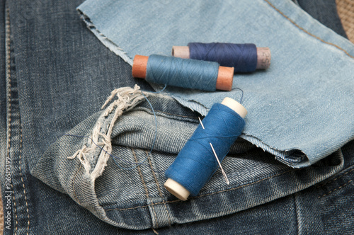 Old torn jeans on a background of burlap. 