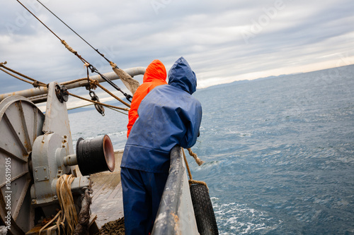 Fishermen in waterproof suits on the deck of the fishing vessel