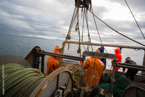 Fishermen in waterproof suits on the deck of fishing seiner