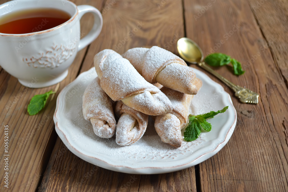 Bagels with jam in powdered sugar with tea for breakfast Bagels with jam in powdered sugar with tea for breakfast