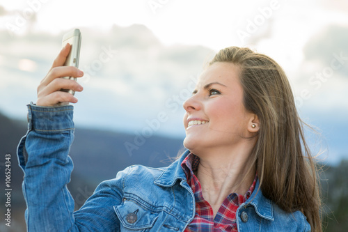 Schöne  Frau macht Selfie in der Natur