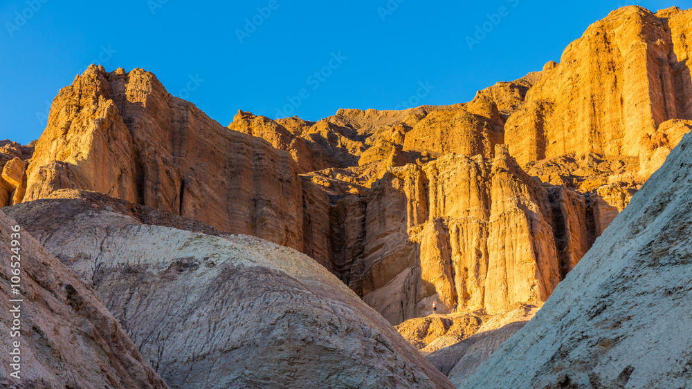 Obraz premium Red Cathedral seen from the Golden Canyon trail. Narrow canyon with vertical walls on both sides. Rocky landscape background. Sandstone formations in Golden canyon, Death Valley
