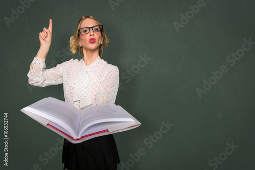 Smart nerd teacher substitute lecturing class with text book in classroom space for print photo