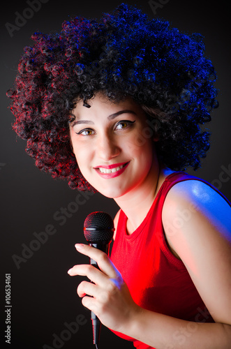 Woman with afro hairstyle singing in karaoke