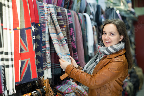 Woman choosing scarf in shop
