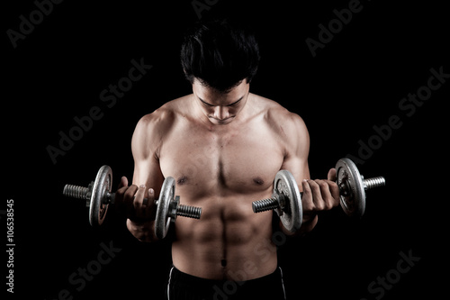 Muscular Asian man with dumbbell