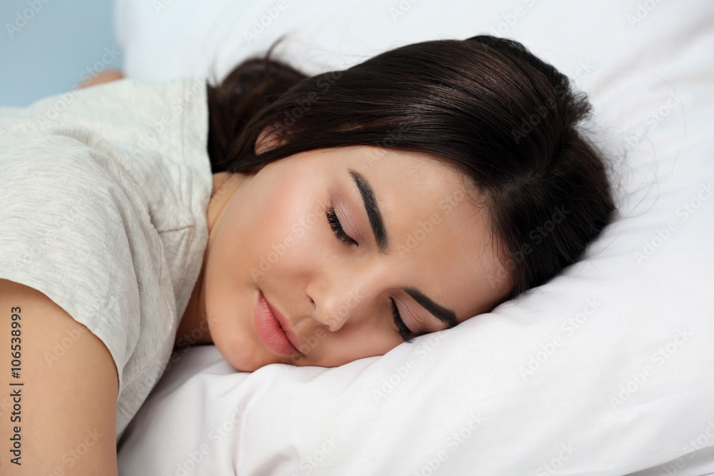 Young woman in pajamas sleeping on bed, close up Young woman in pajamas sleeping on bed, close up