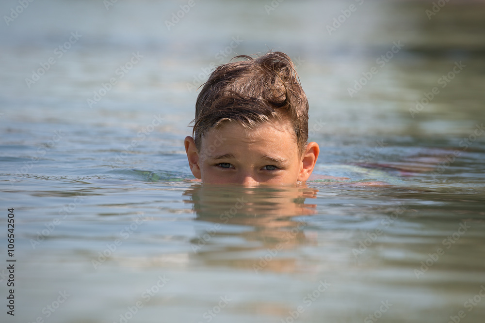 Portrait happy teenager in sea water