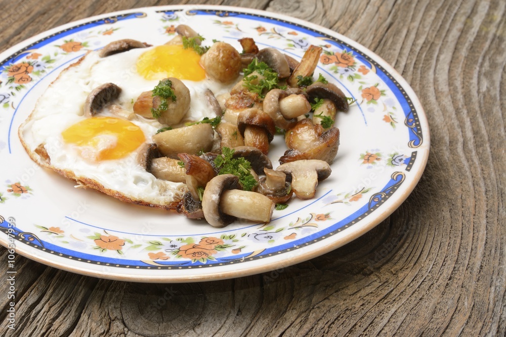 fried eggs on rustic table with mushrooms fried eggs on rustic table with mushrooms