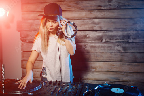Obraz na plátně Cute dj woman having fun playing music at club party