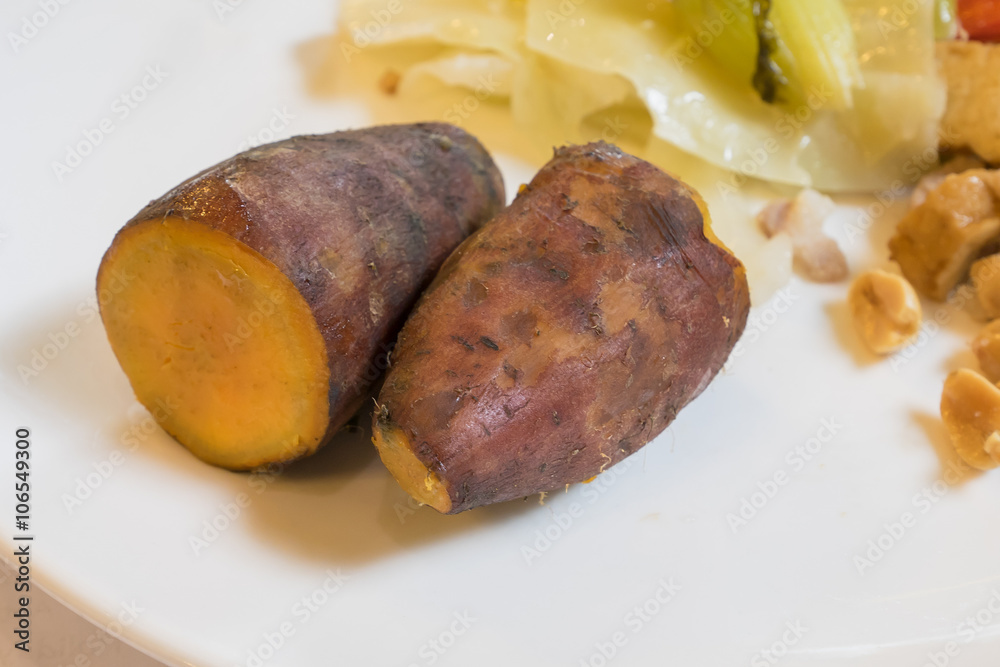 The close up of delicious sweet potato with food on white plate. The close up of delicious sweet potato with food on white plate.