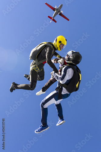 Two girls and a guy skydivers jump out of an airplane. © German Skydiver