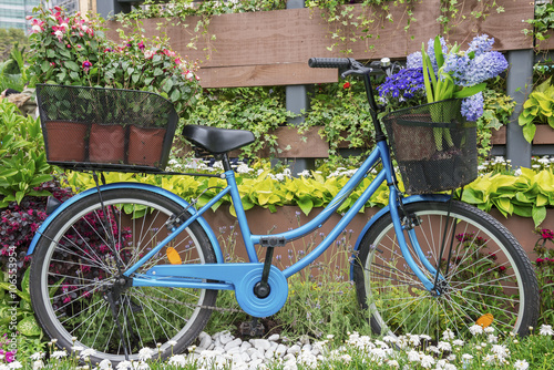 bicycle equipped with baskets of flowers in garden