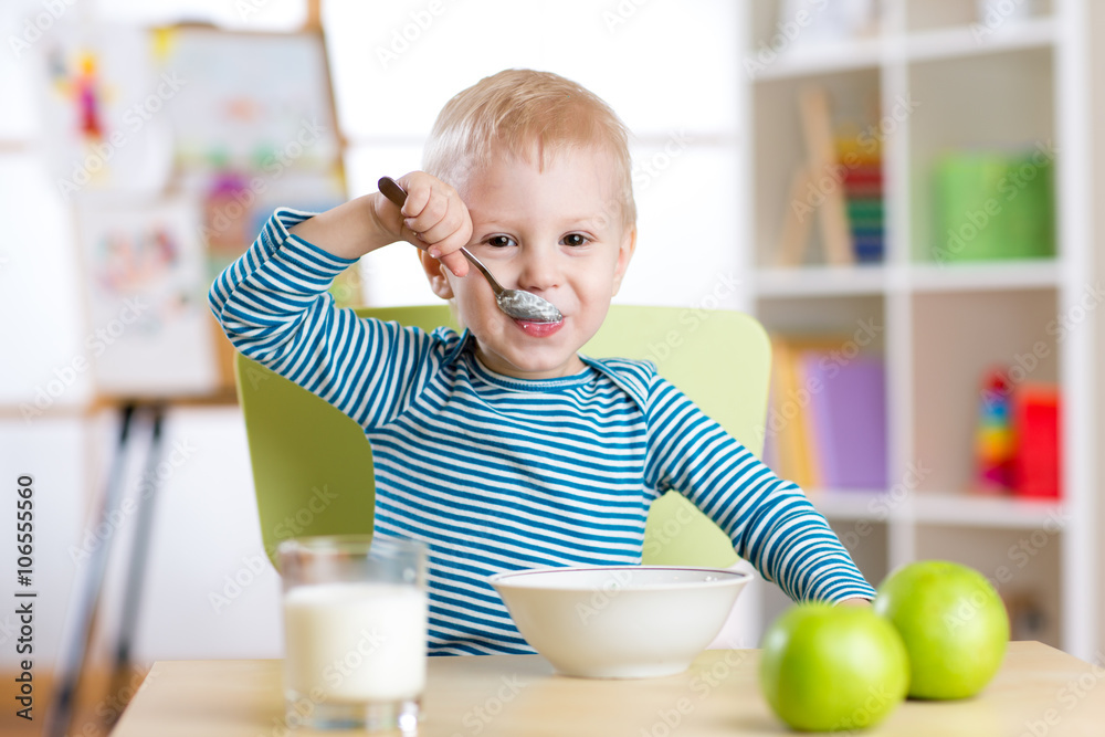 kid boy eating healthy food at home or daycare kid boy eating healthy food at home or daycare