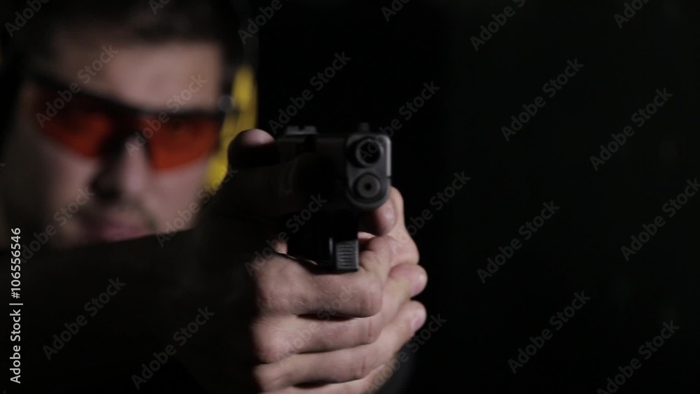 Holding a pistol over black background Holding a pistol over black background
