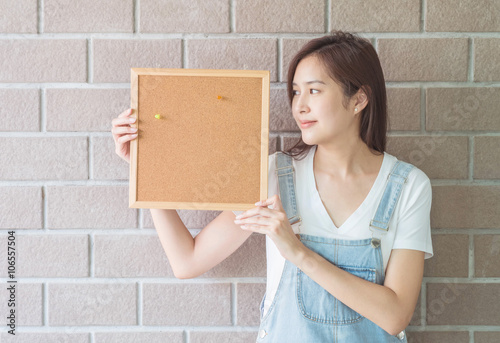 Asian woman with cork board in hand with smiling face