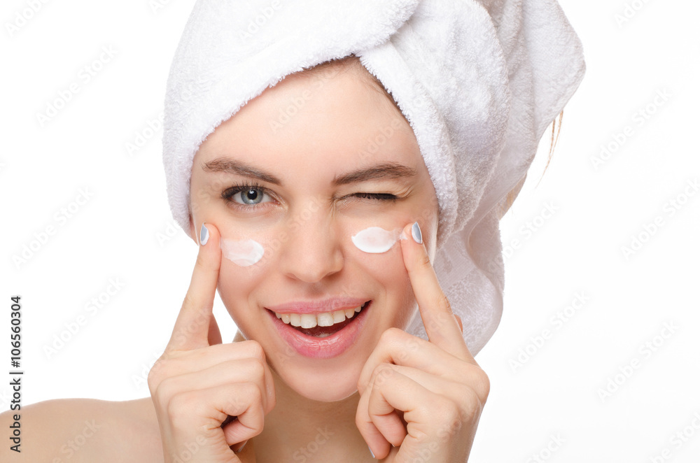 Beautiful young woman applying a creme on her face isolated on white background Beautiful young woman applying a creme on her face isolated on white background