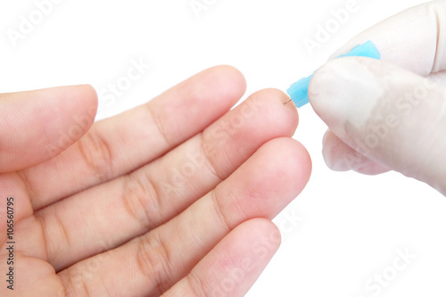 blue blood lancet penetrates to the skin of left hand 
