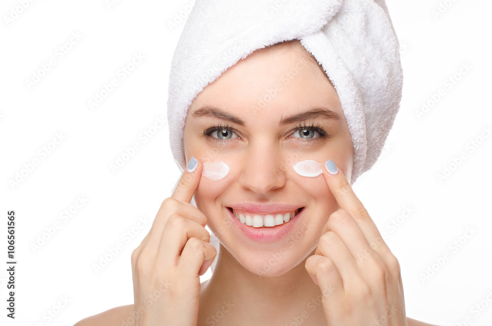 Beautiful young woman applying a creme on her face isolated on white background Beautiful young woman applying a creme on her face isolated on white background