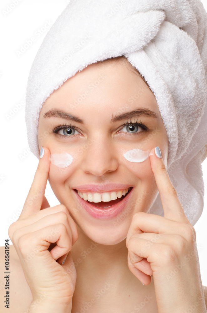 Beautiful young woman applying a creme on her face isolated on white background Beautiful young woman applying a creme on her face isolated on white background