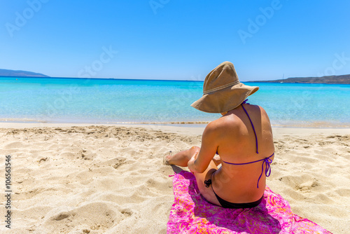 Beautiful young woman lying on the magnificent beach of Elafonis