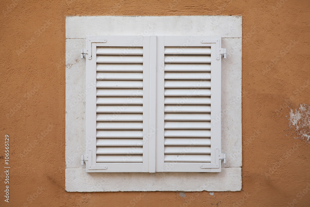 White window with shutters in yellow wall Stock Photo | Adobe Stock
