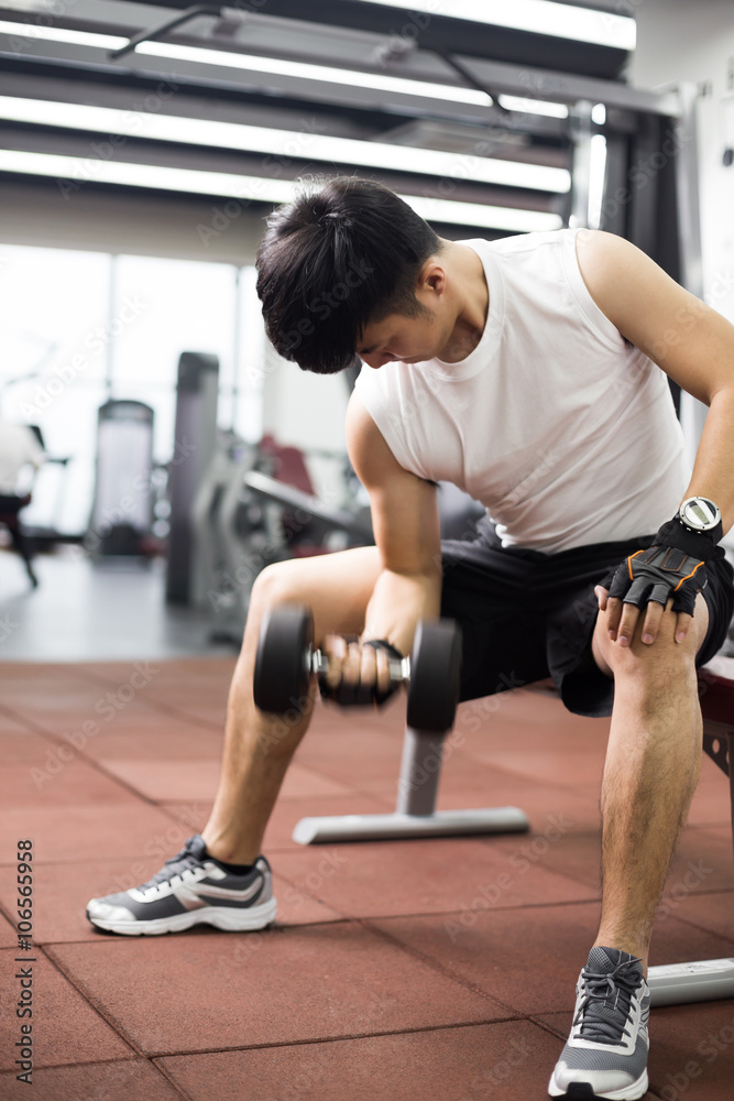 young handsome asian man works out in modern gym young handsome asian man works out in modern gym
