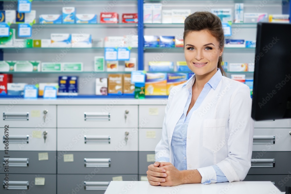 Beautiful smiling young woman pharmacist doing his work in pharmacy. Beautiful smiling young woman pharmacist doing his work in pharmacy.
