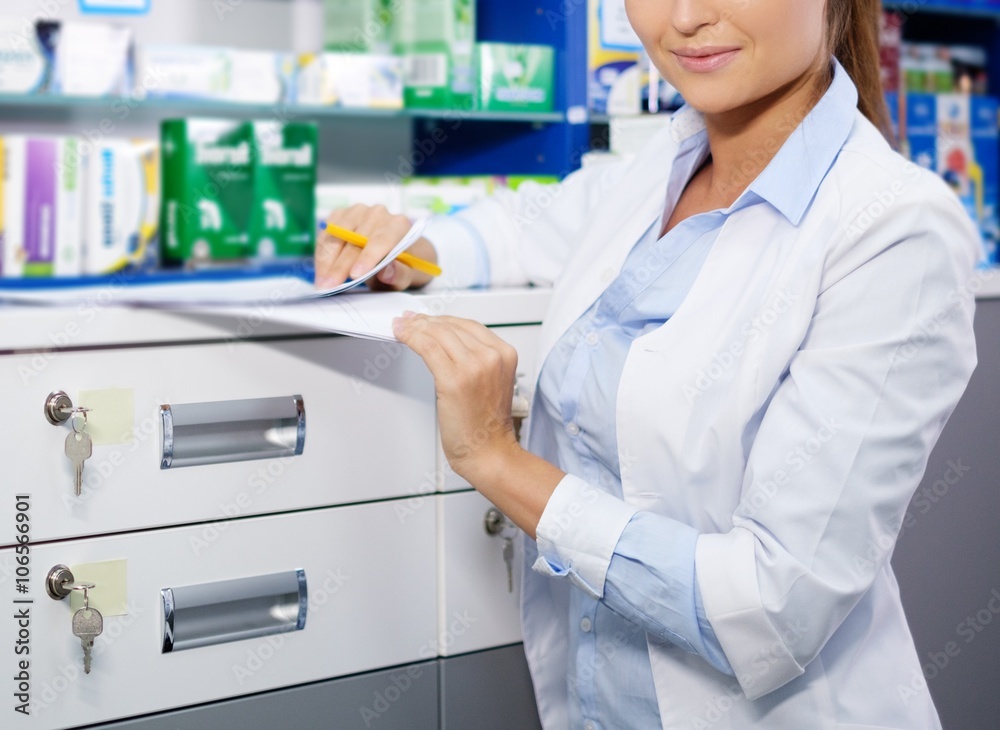 Beautiful smiling young woman pharmacist doing his work in pharmacy. Beautiful smiling young woman pharmacist doing his work in pharmacy.