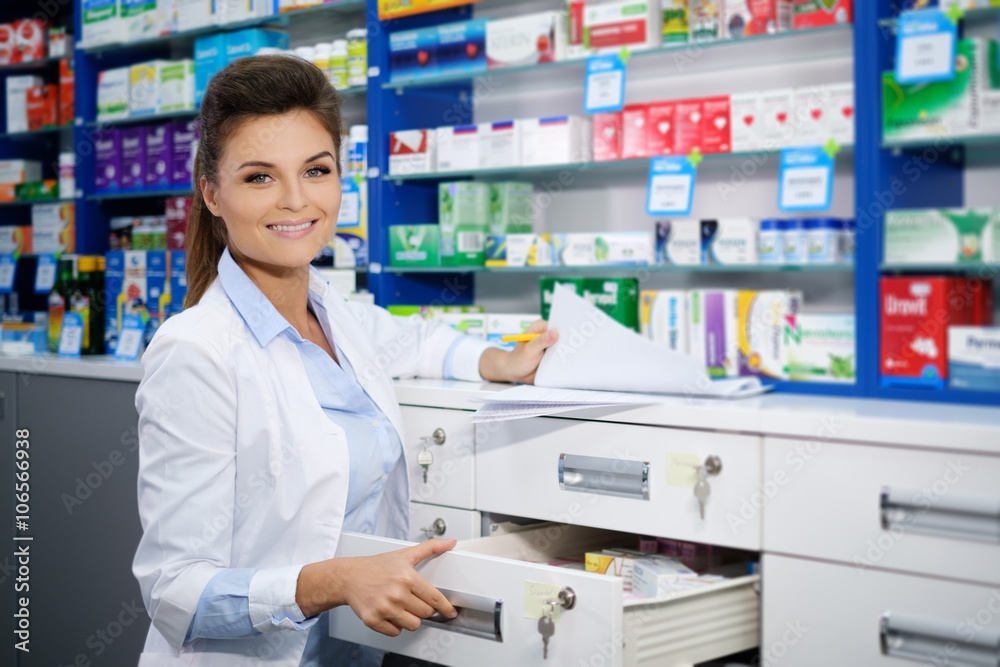 Beautiful smiling young woman pharmacist doing his work in pharmacy.