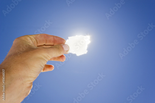 Piece of salt in hand against sun