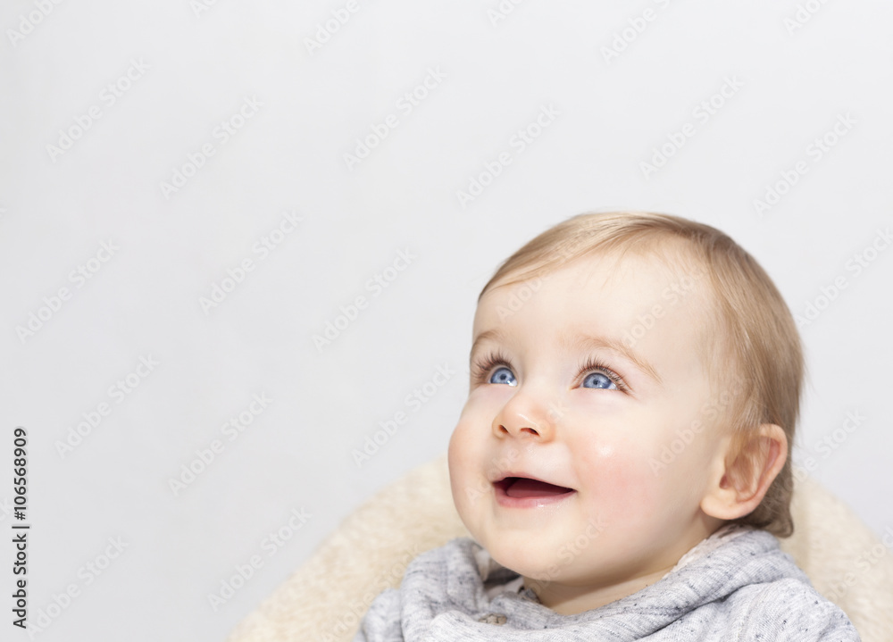 Adorable baby boy looking up on grey background Adorable baby boy looking up on grey background
