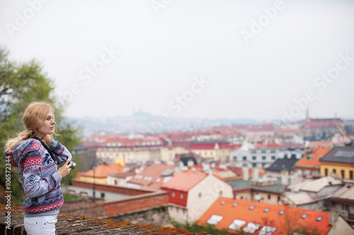 girl with a camera on the background of Prague