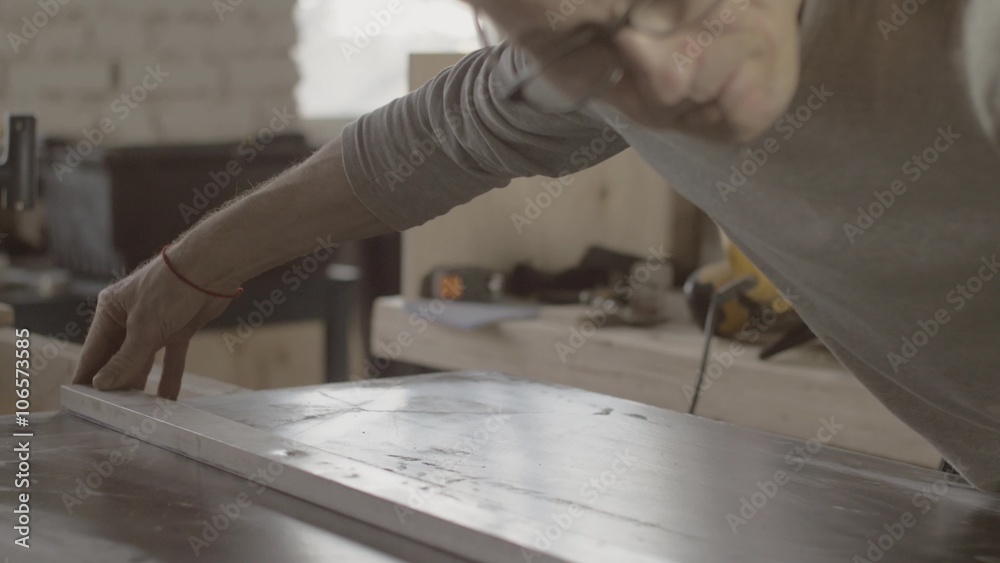 Face of woodworker in glasses measure wooden board by straightedge. Furniture. Close up. Manufacturer. Face of woodworker in glasses measure wooden board by straightedge. Furniture. Close up. Manufacturer.