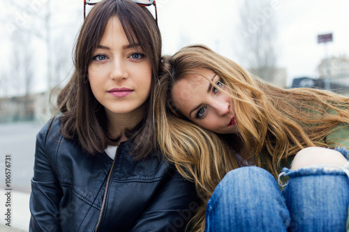 Beautiful young women looking at camera in the street.