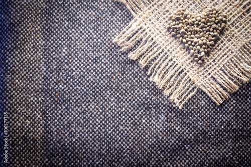 Hemp (cannabis) seeds heart on hemp fabric background