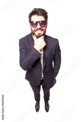 Full height Confident young handsome man in sunglasses hand on chin and looking at camera while standing against white background.