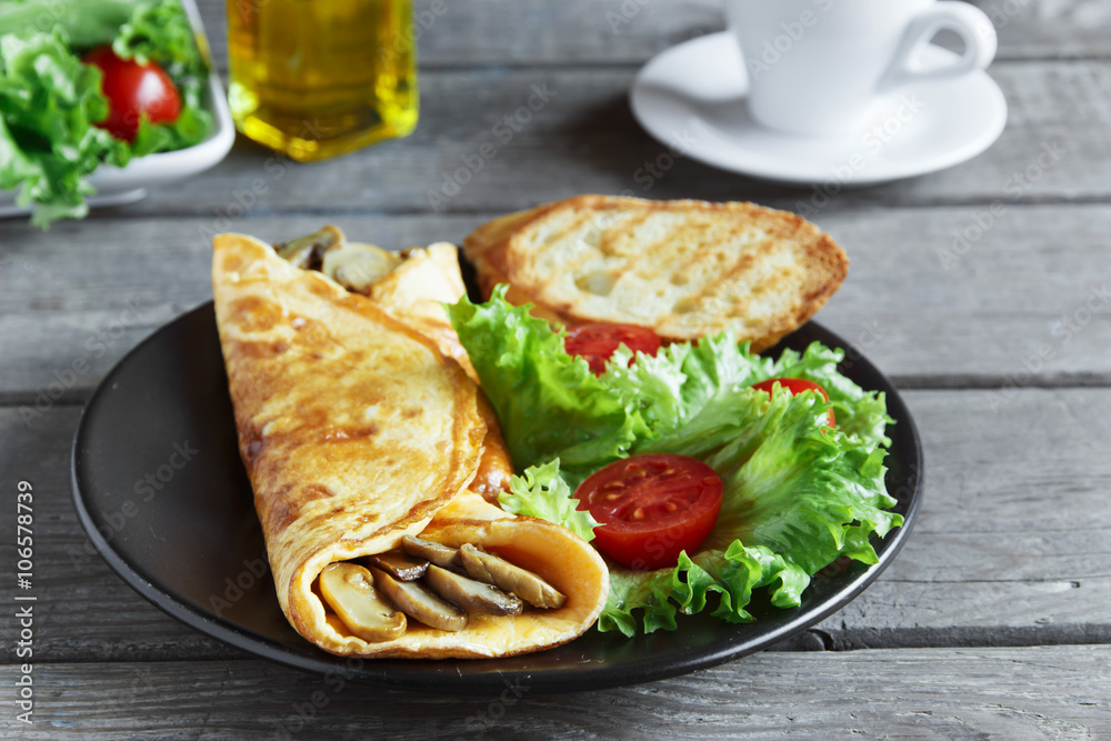 omelet with mushrooms on a plate with salad and tomato