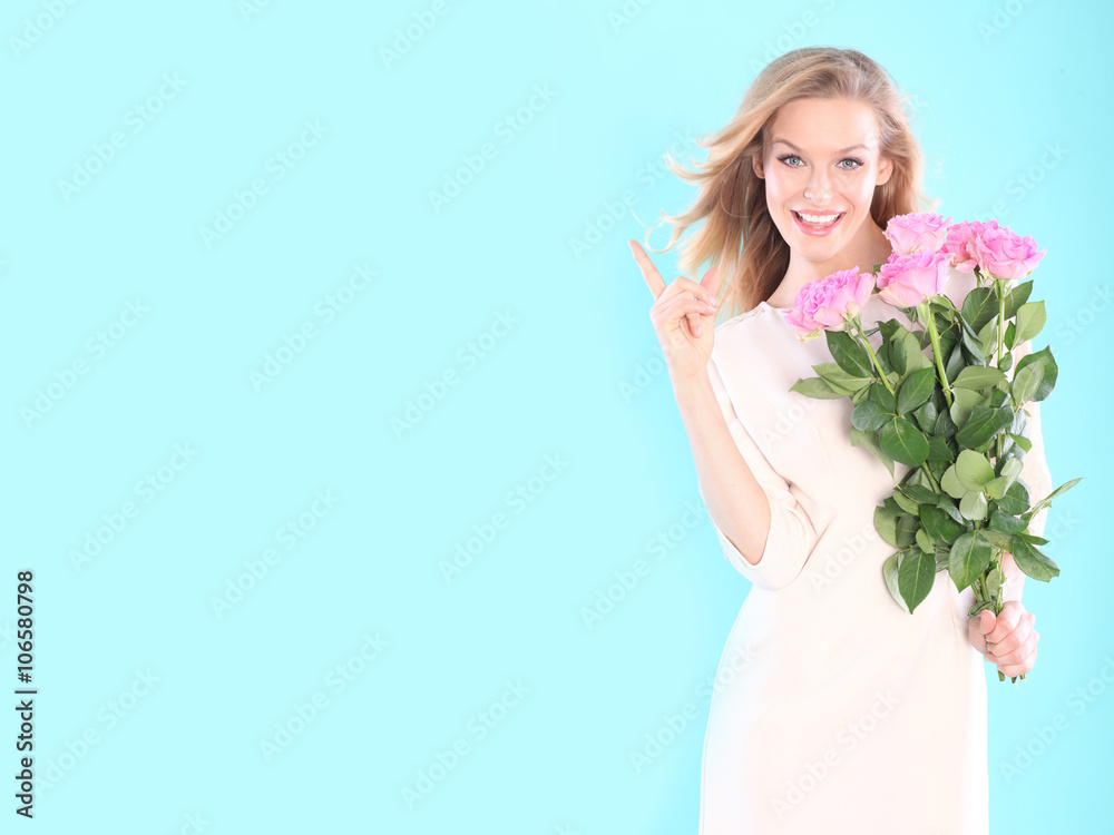 Beautiful woman with a bouquet of roses. Blue background 