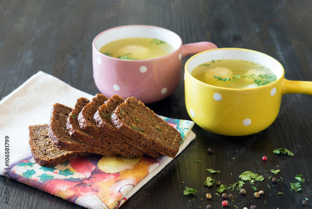 soup with meatballs in colorful bowl with slices of grain bread soup with meatballs in colorful bowl with slices of grain bread