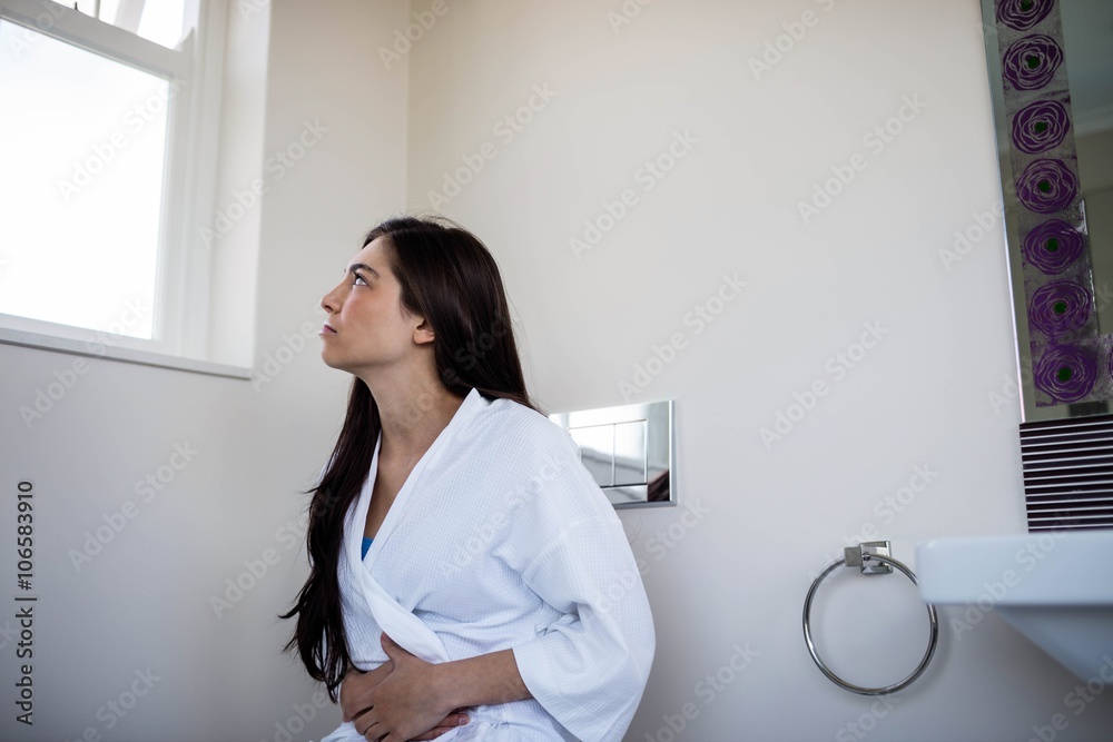 Woman in bathrobe with bellyache